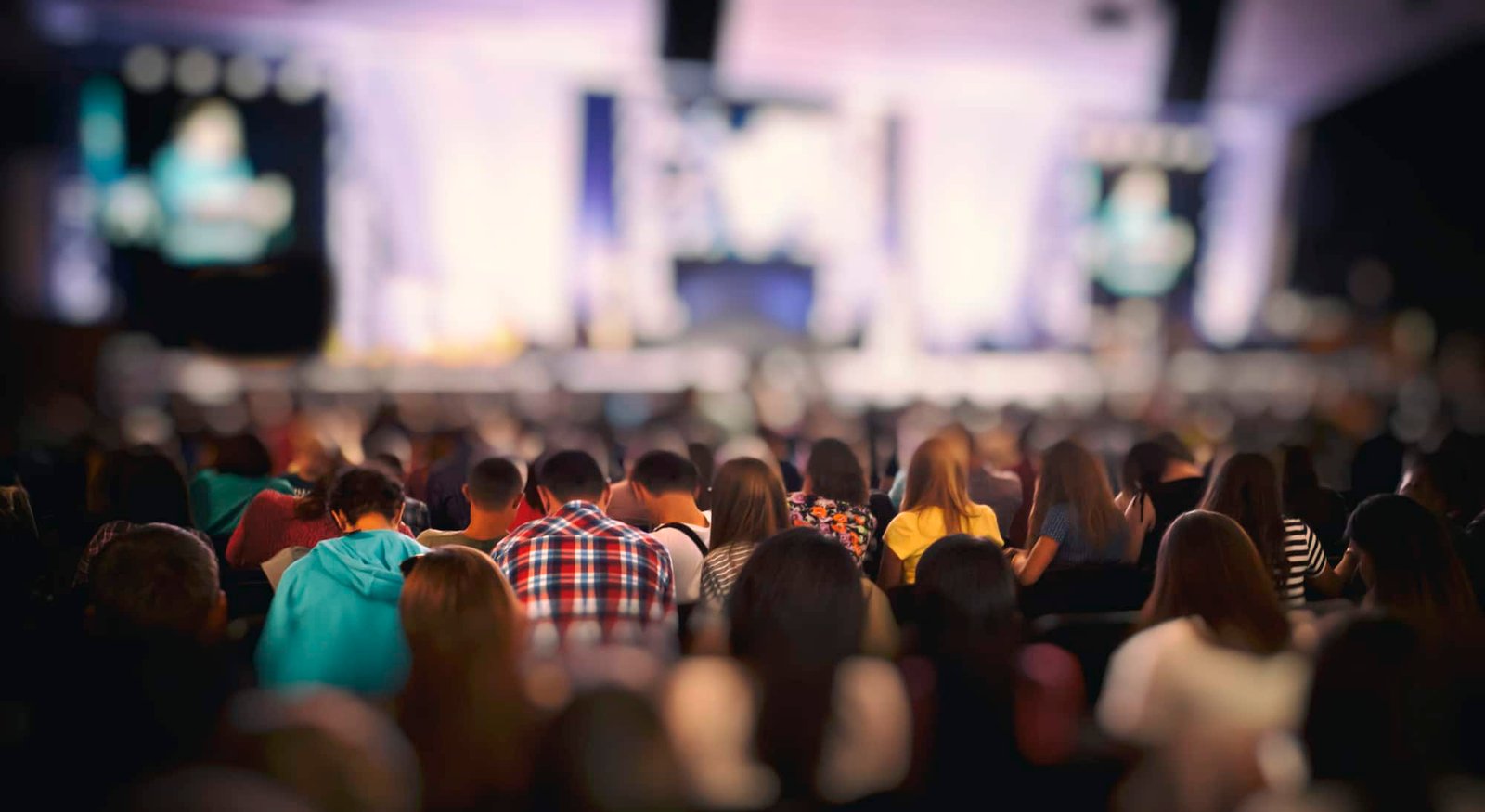 Interns listening to the lecturer in the dark conference room with media equipment