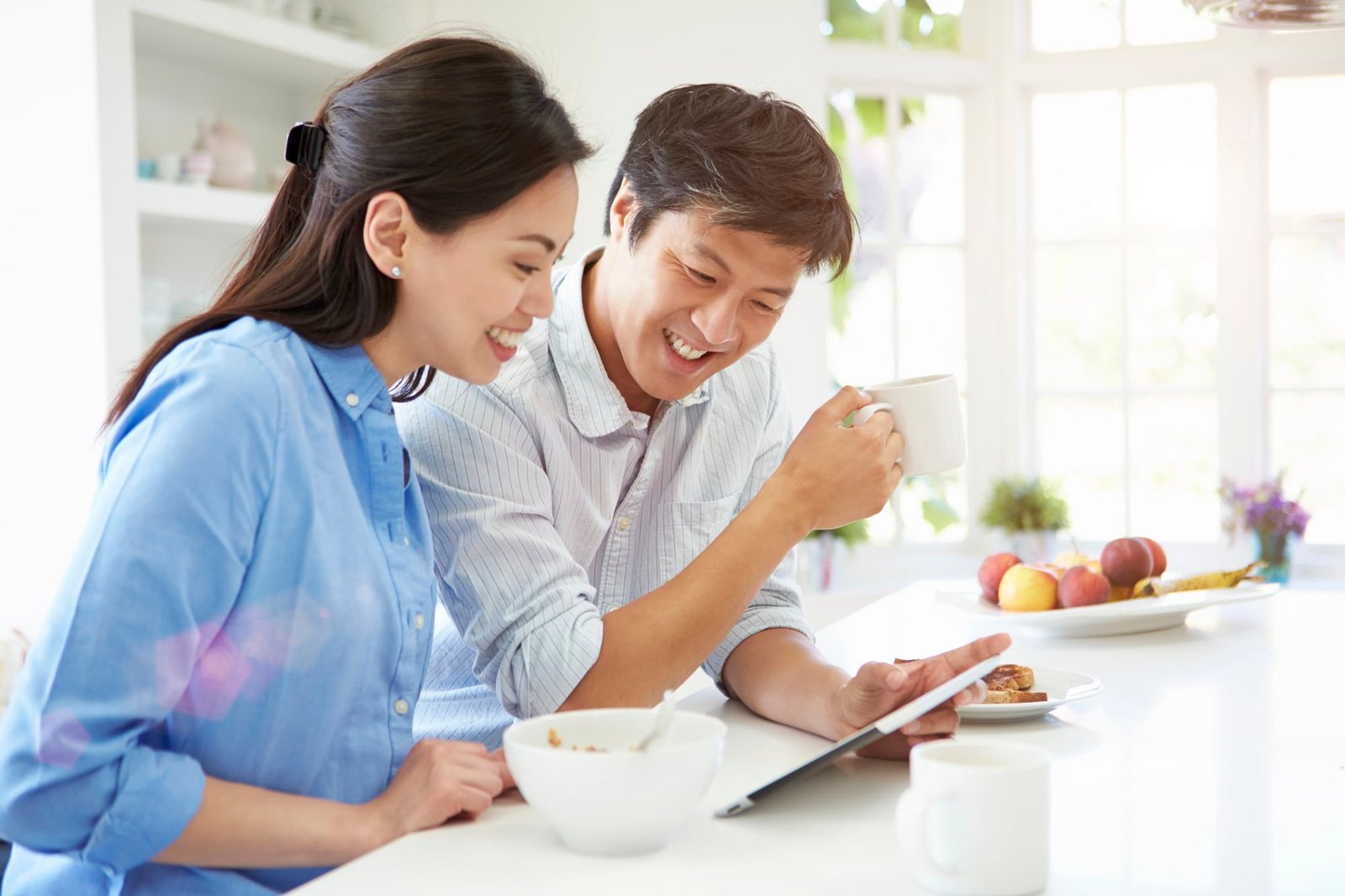 Wife and husband having a quality time together in they joint white appartment playing piano four hand