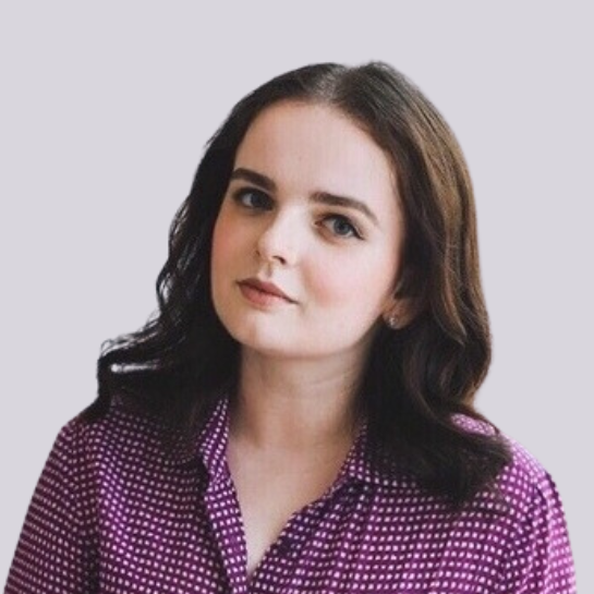 Портрет Надежды, молодой женщины с темными волнистыми волосами, в фиолетовой узорчатой блузке, уверенно смотрящей в камеру.