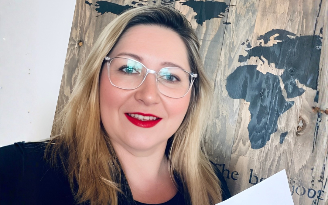 Olga Prygoda, Managing Attorney for the Corporate Practice at Stelmakh & Associates, smiling in front of a world map background.