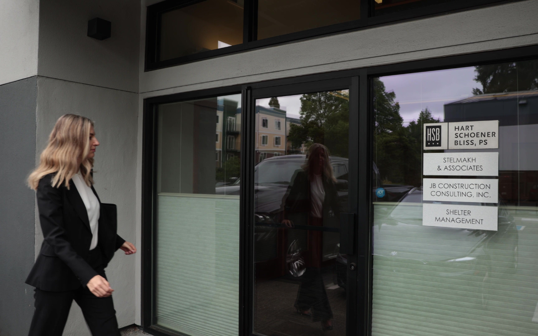 Katya Stelmakh se dirige vers l'entrée du bureau de Stelmakh & Associates, vêtue d'un costume noir et d'un chemisier blanc.